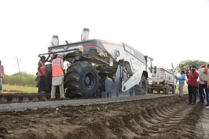 Road stabiliser machine working on a rural road base in Uttar Pradesh
